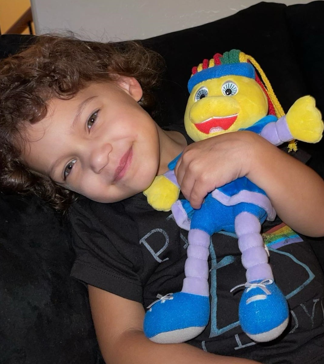 A child resting with the Toley Ranz plush.