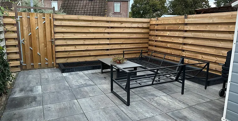 Nieuw bestraat terras met schutting en loungeset na de renovatie — Bronneger Exclusive in Drenthe