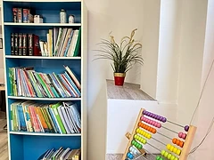 Estantería azul con materiales educativos y ábaco