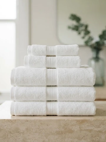 Stack of crisp white towels on a stone vanity