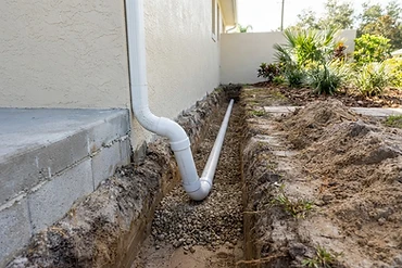 Underground drainage pipe trenched along a Florida foundation
