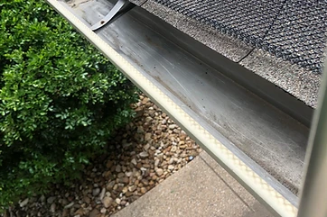 Cleaned-out gutter with mesh guard reseated after cleaning