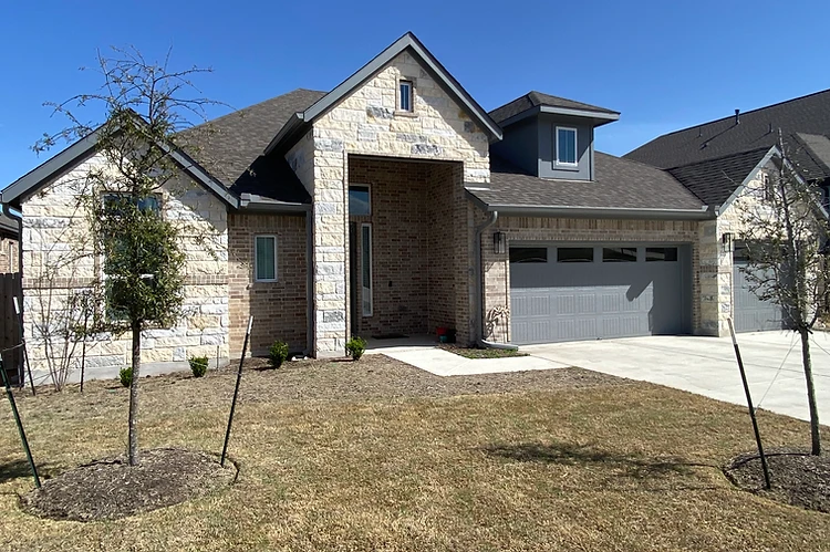 Stone home in the Austin area with seamless gutters installed on every roof plane by 911 Gutter Team