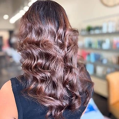 Long chestnut-brown hair with auburn highlights in loose voluminous waves