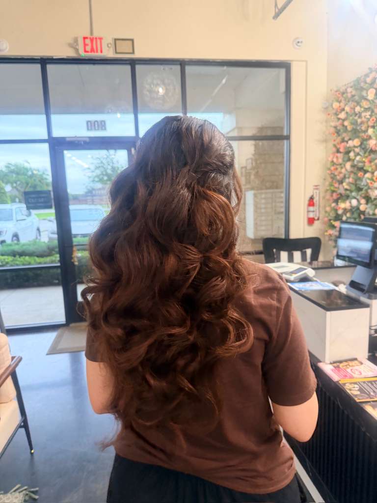 Long chestnut-brown hair styled half-up in loose waves