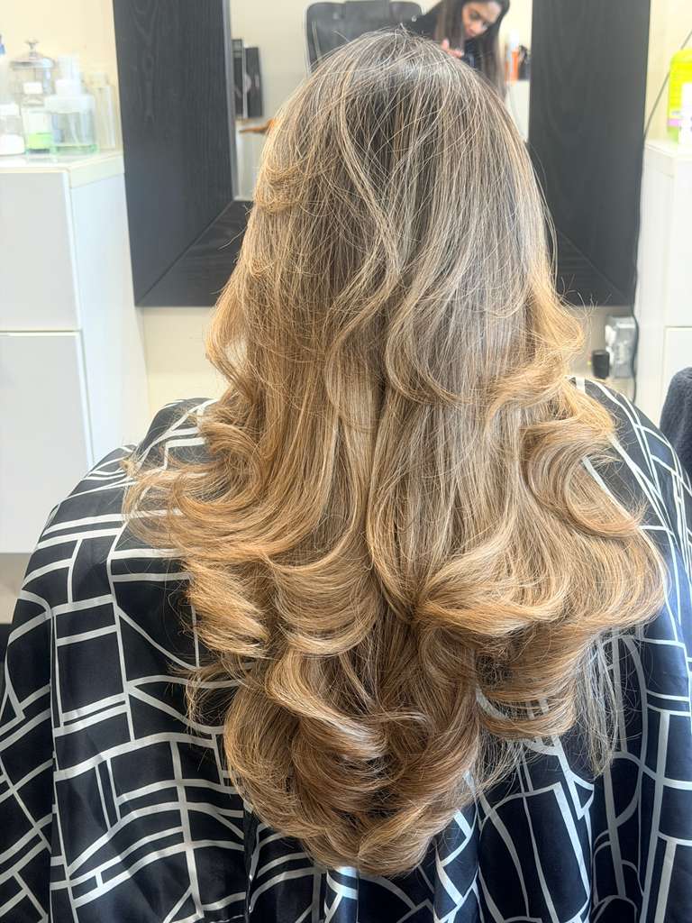 Light brown hair with golden highlights in loose layered curls
