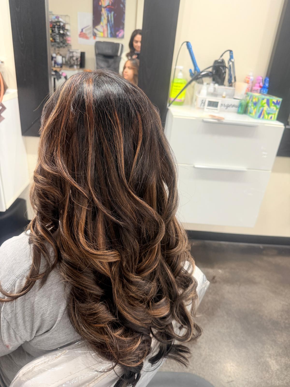 Dark brown hair with caramel copper highlights in loose voluminous curls