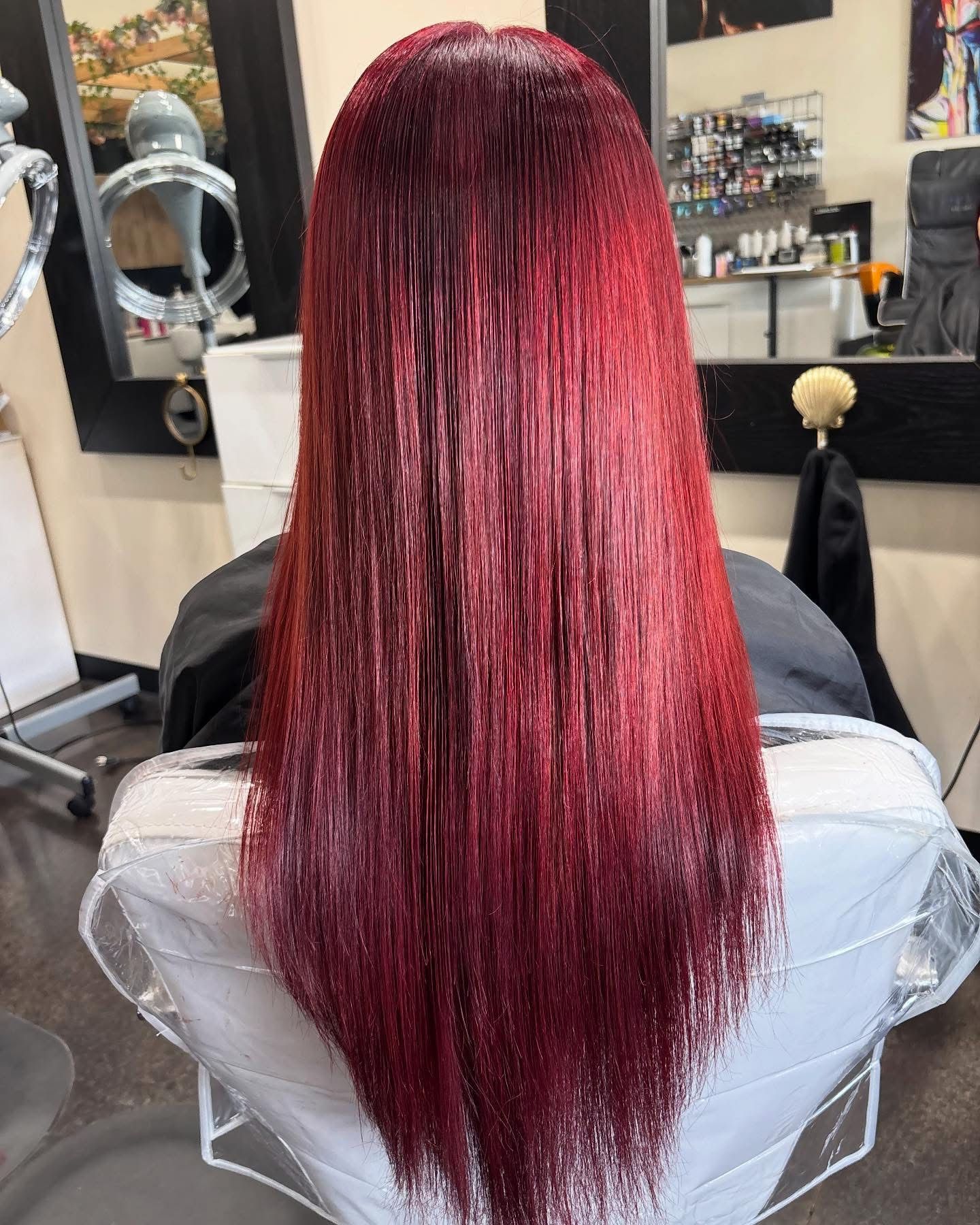 Long straight hair dyed a vivid cherry red magenta with a glossy finish
