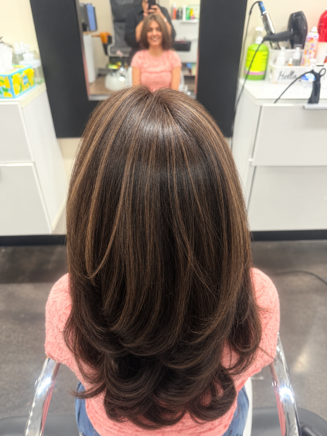 Dark brown hair with reddish-brown highlights in soft layers curving inward at the ends