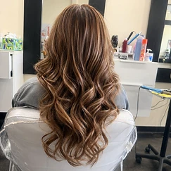 Long wavy brown hair with caramel highlights in loose voluminous waves