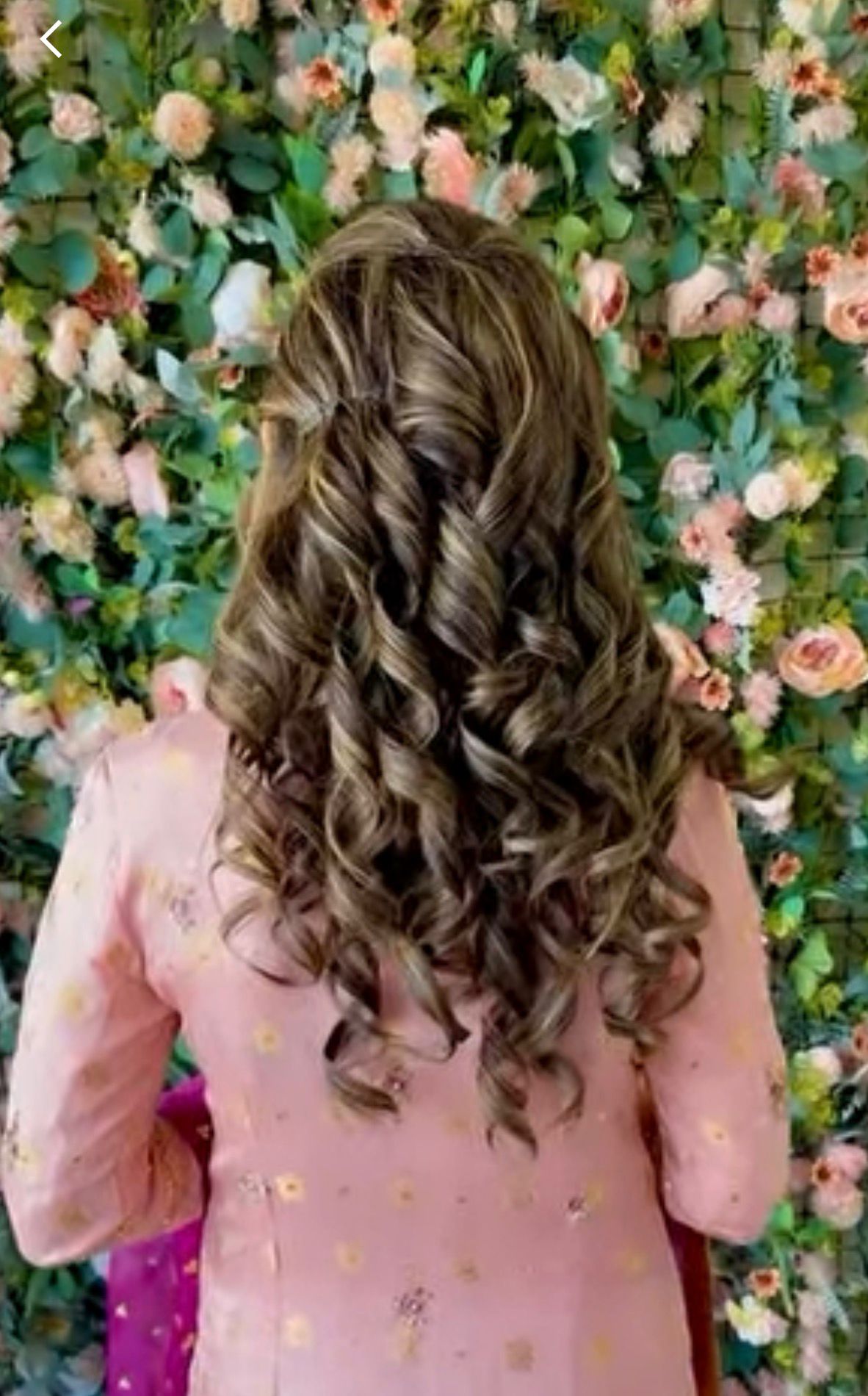 Long brown hair with caramel highlights in defined cascading curls