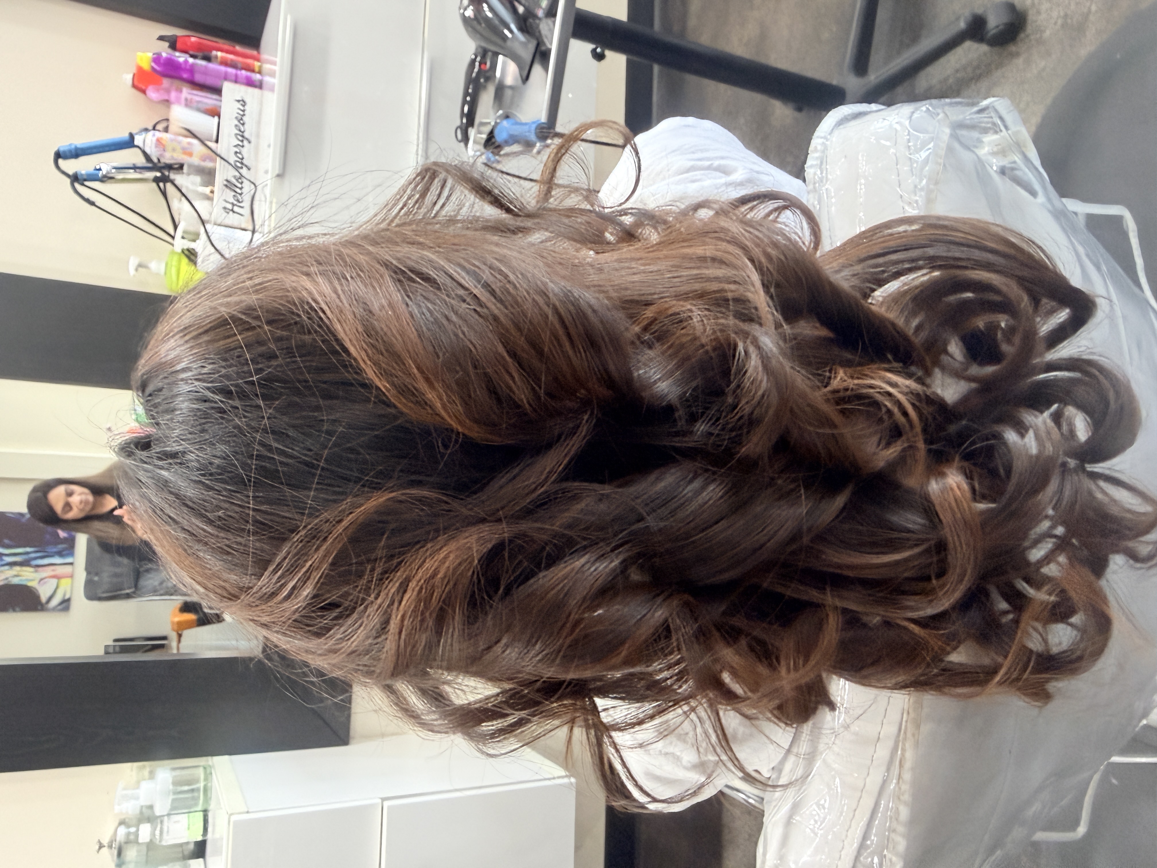 Dark brown hair with balayage highlights in loose flowing curls