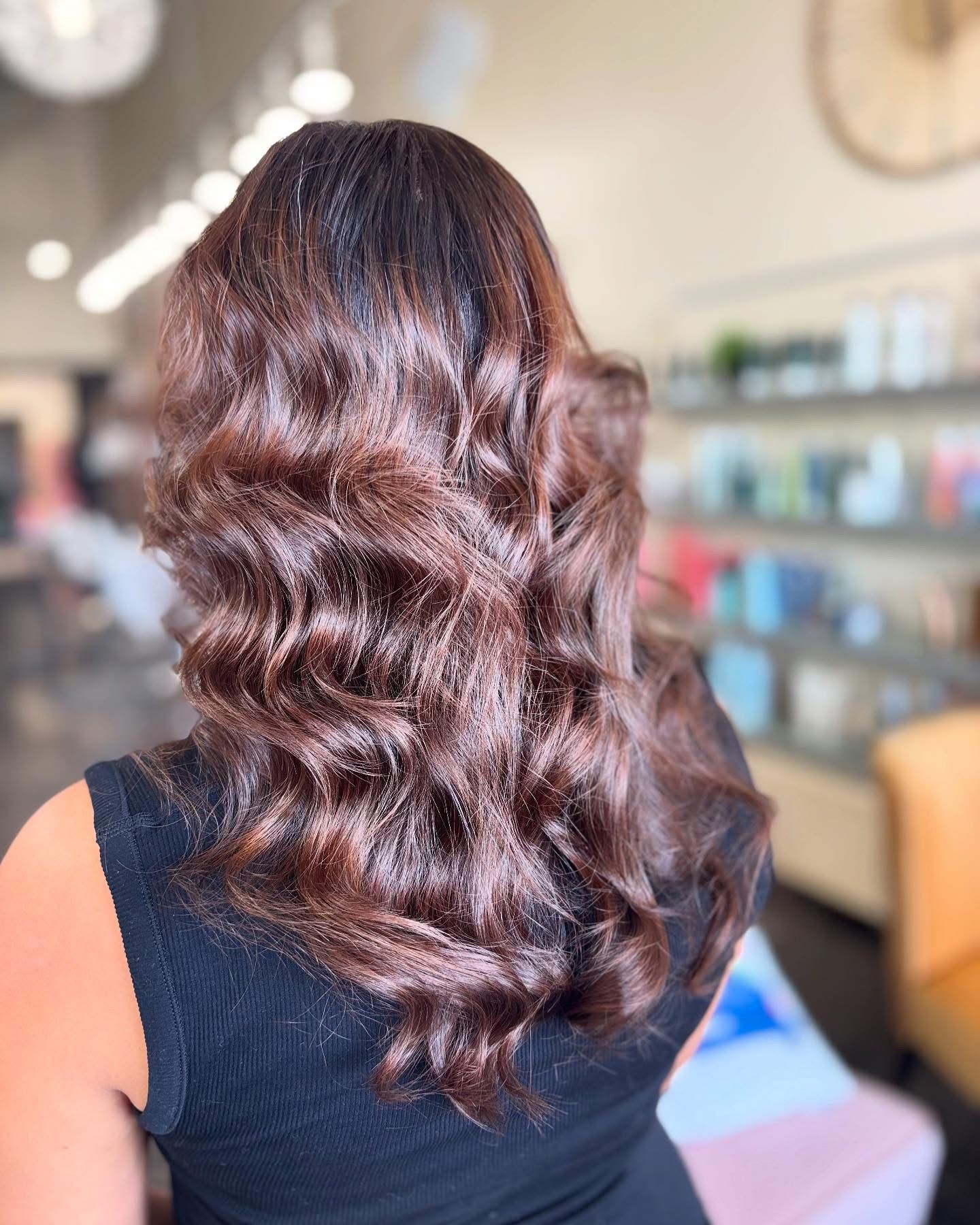 Voluminous auburn reddish-brown hair in loose waves