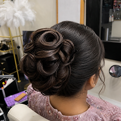 Dark brown hair sculpted into a rose-shaped bun updo for a formal event