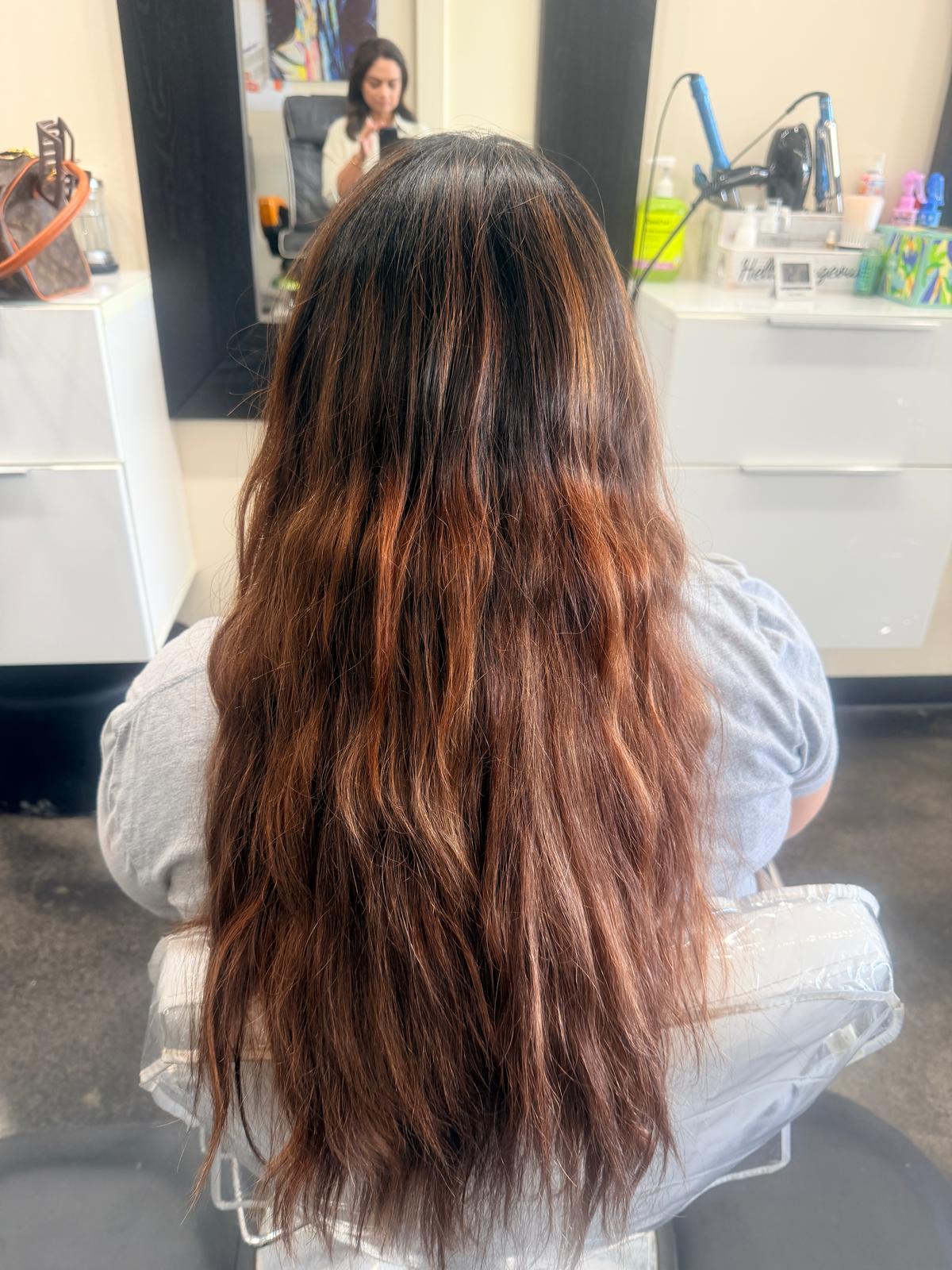 Long dark brown hair with copper auburn balayage in loose soft waves