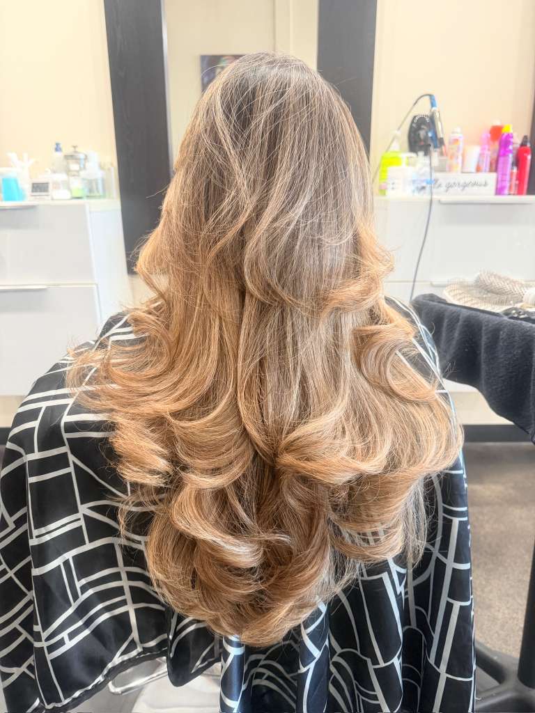 Long light brown hair with caramel tones in loose voluminous curls