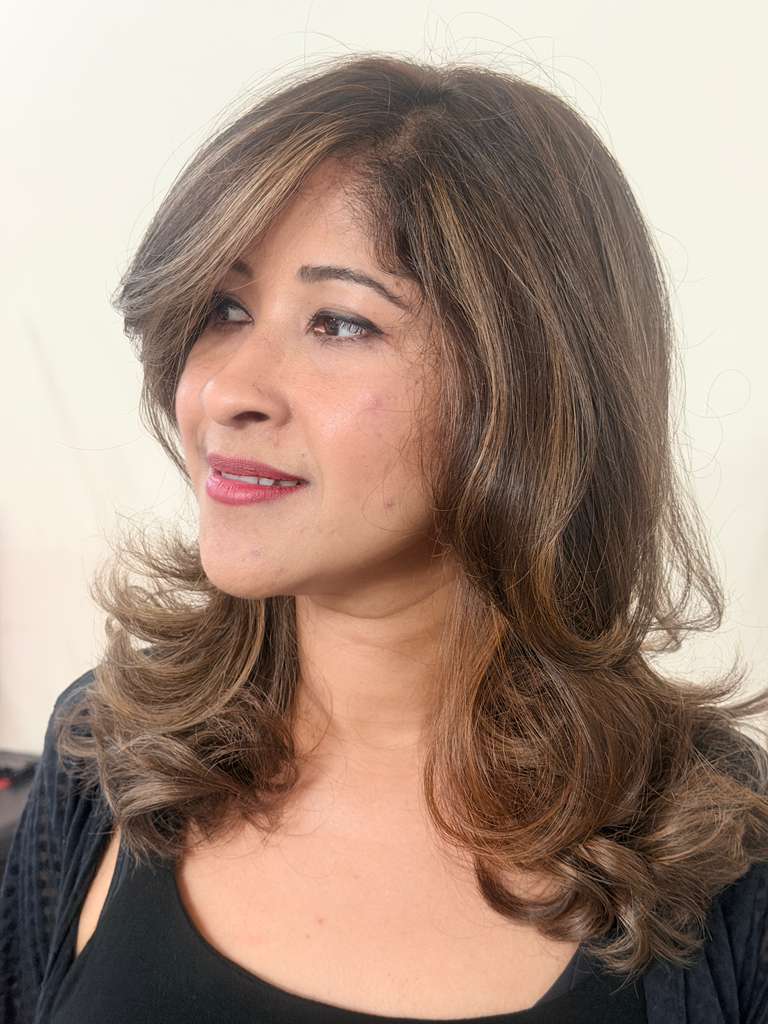 Medium-length layered chestnut hair with golden-brown highlights in soft waves