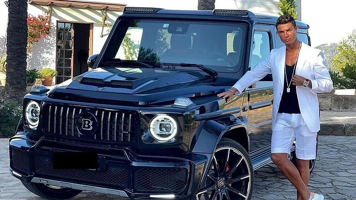 Cristiano Ronaldo standing next to a black Brabus Mercedes-Benz G-Wagon, one of the most expensive cars in his reported collection