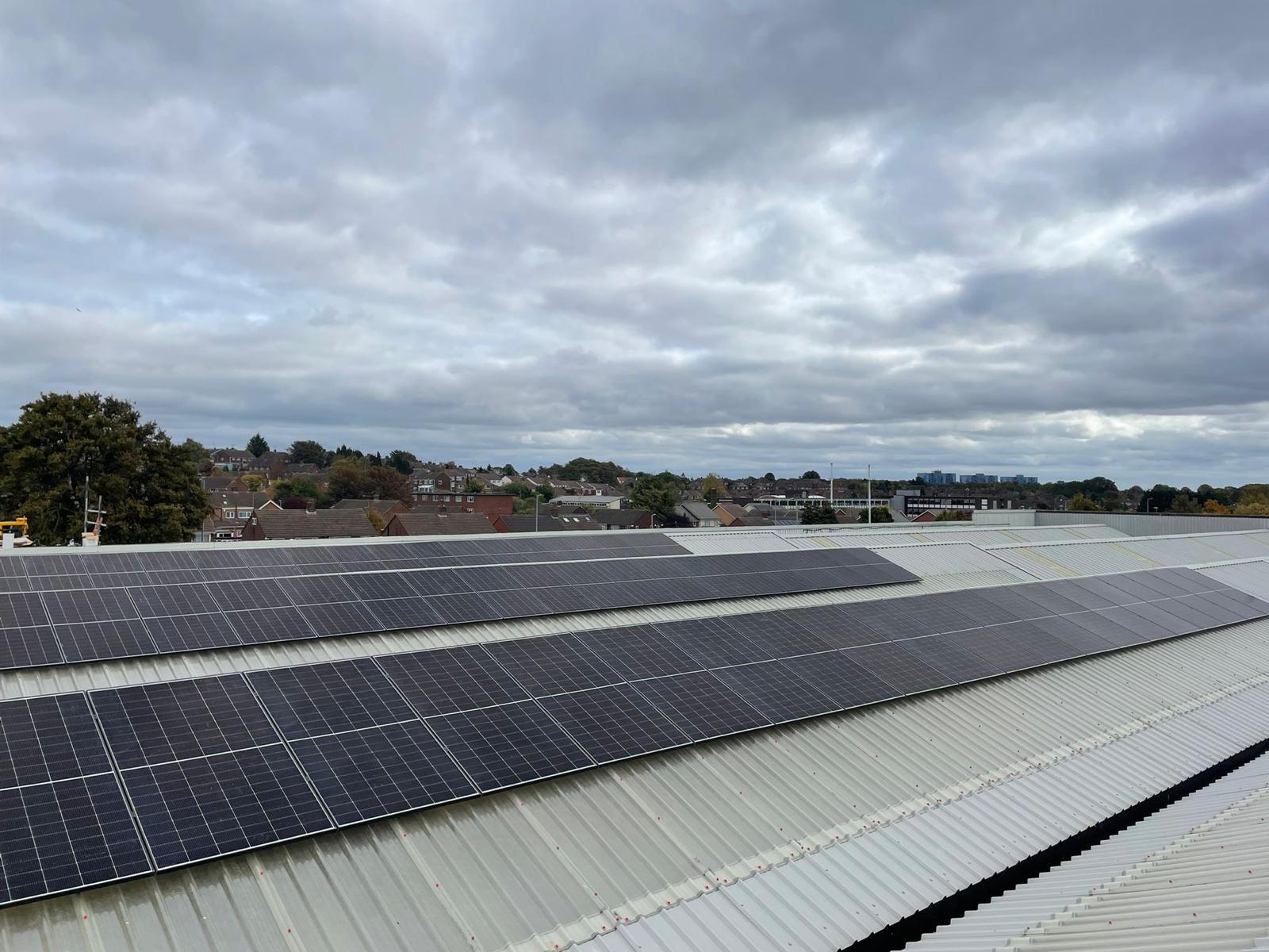 Aerial view of a completed commercial solar panel installation on a metal roof