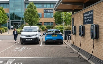 Electric van and car charging at a row of workplace EV charge points