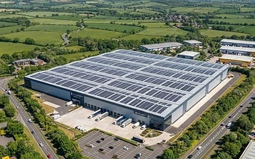 Rows of solar panels covering the roof of a commercial warehouse