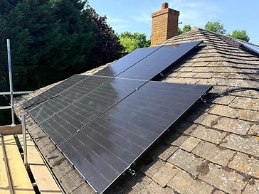 Flush-mount black solar panels in a 3x2 grid on a tiled residential roof with a wire bird guard and brick chimney