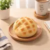 Crunchy Bolo Bun squishy on a wooden plate