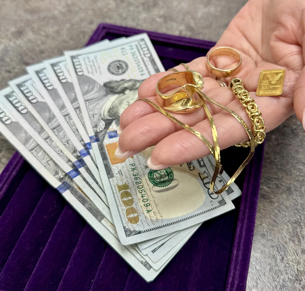 Cash for gold — hundred dollar bills with gold jewelry at Arthurs Gold Market, Rego Park