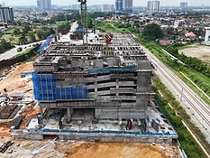 Aerial view of The Asteriaz construction site, Q3 2026 — tower crane and concrete pumping beside railway tracks