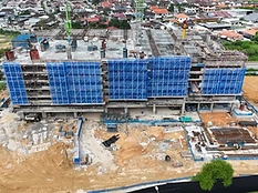 Aerial drone view of The Asteriaz construction site, Q3 2026 — multi-storey concrete frame with blue safety netting