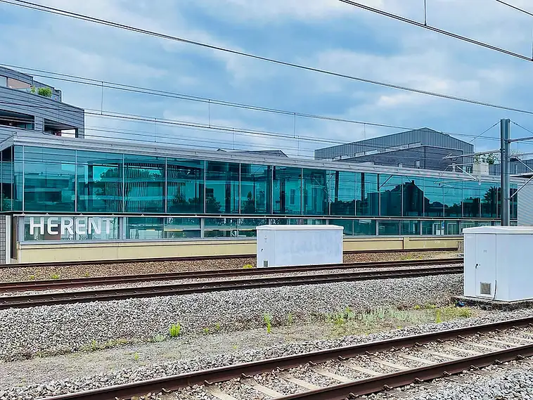 Treinstation van Herent met glazen perronoverkapping en sporen, herkenningspunt voor een EPC-keuring in Herent