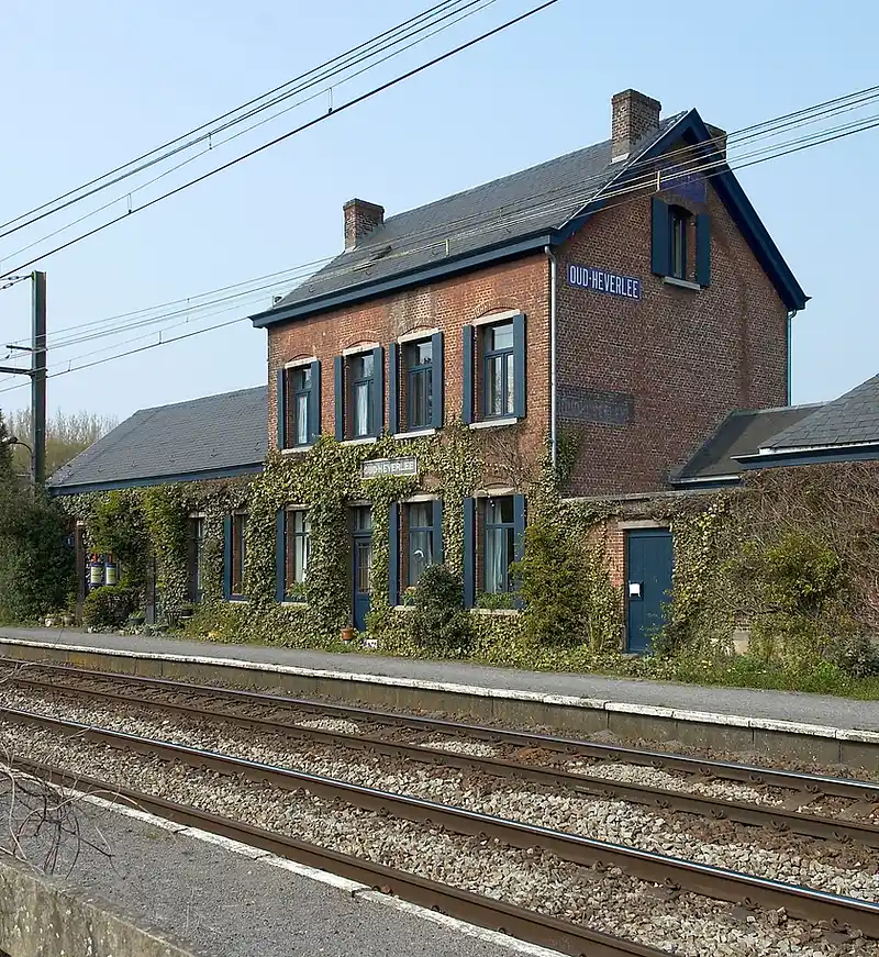 Treinstation van Oud-Heverlee met bakstenen gebouw en blauw naambord, herkenningspunt voor een EPC-keuring in Oud-Heverlee