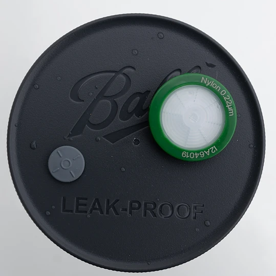 Close-up of the grey self-healing injection port on a liquid culture jar lid