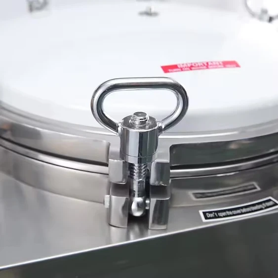 Close-up of the heavy-duty locking toggle mechanism on the autoclave lid