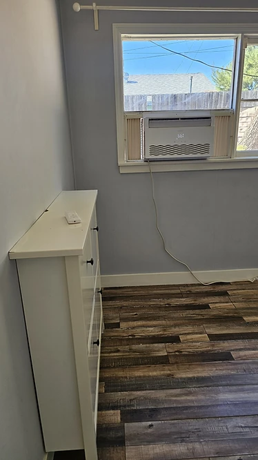 After cleaning — the same storage cabinet and room cleaned, with only a remote control left on top.