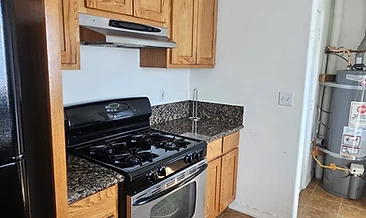 Residential kitchen with honey-oak cabinetry and stainless steel range. Grease and cooking residue on surfaces, backsplash, and range hood.