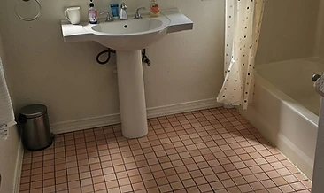 Bathroom vanity area with chrome fixtures and dual windows. Water spots and mineral buildup on faucet, sink basin, and surrounding surfaces.