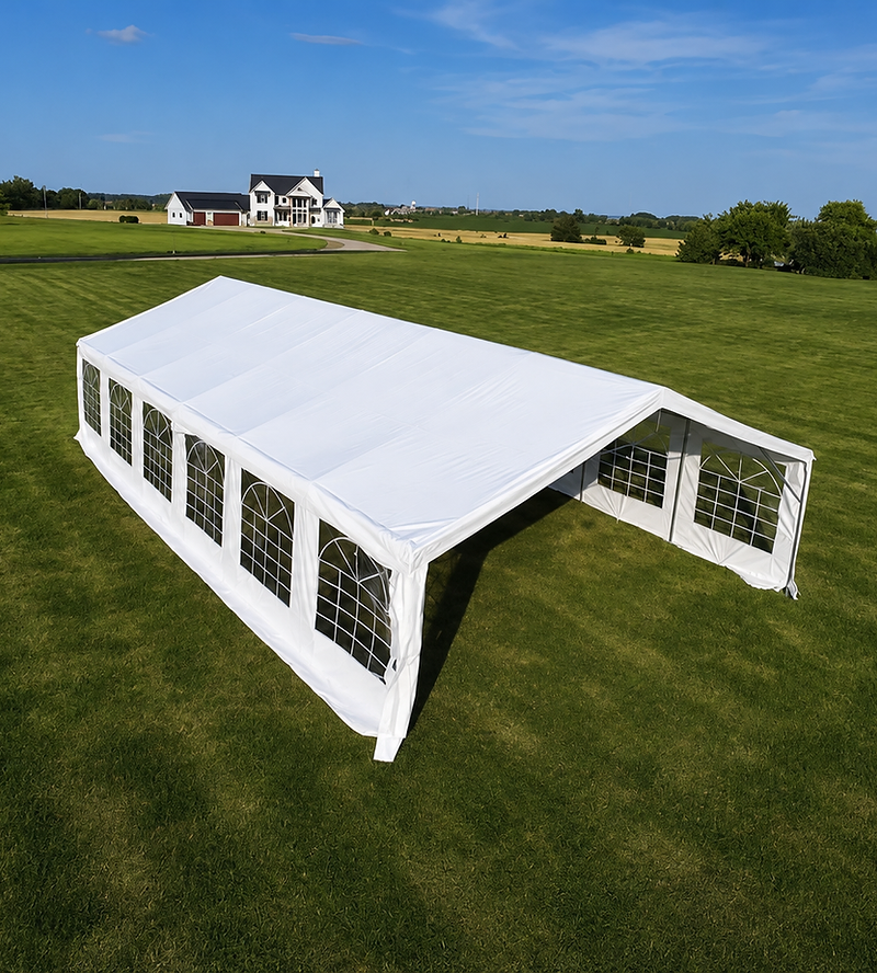 Large white event tent set in a green Wisconsin meadow at golden hour