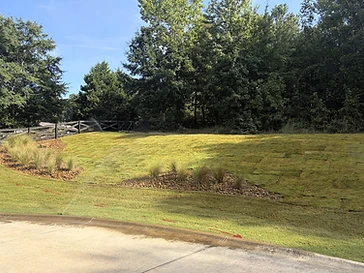 Freshly laid sod on a graded slope with stone beds