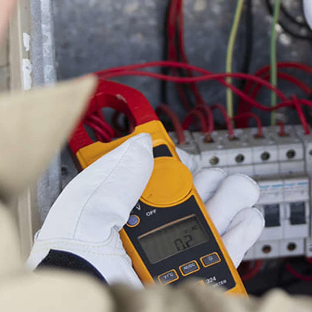 Electrician clamp-testing circuits inside a switchboard