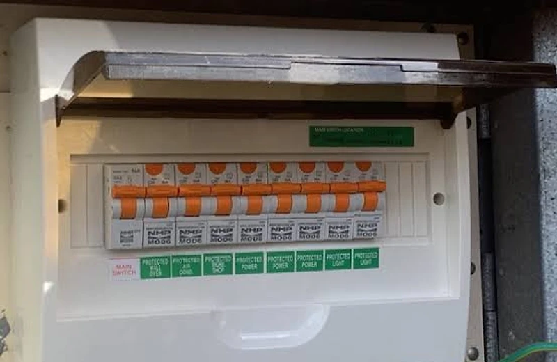 Emergency electrician testing a tripped switchboard at night