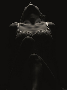 Linn-Kristin E. in a low-key studio portrait, her head tilted back in warm light against black
