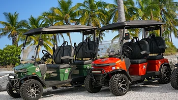 Green and orange golf carts on gravel