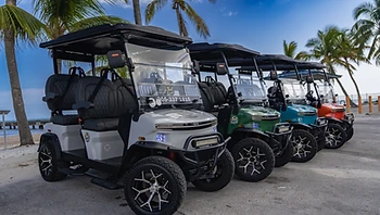 Four colorful golf carts in a row