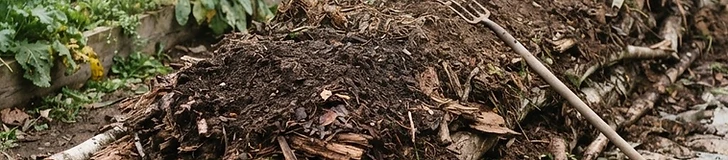 A cross-section diagram of a garden bed showing layers of logs, branches, soil, and compost with leafy vegetables growing on top.