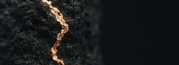 A natural gold vein running through dark rock