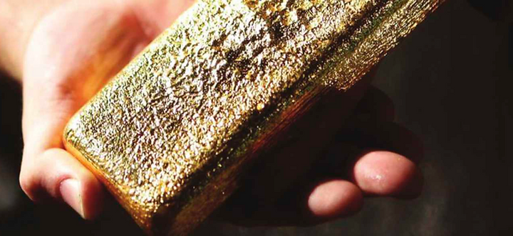 A gold bar held in hand