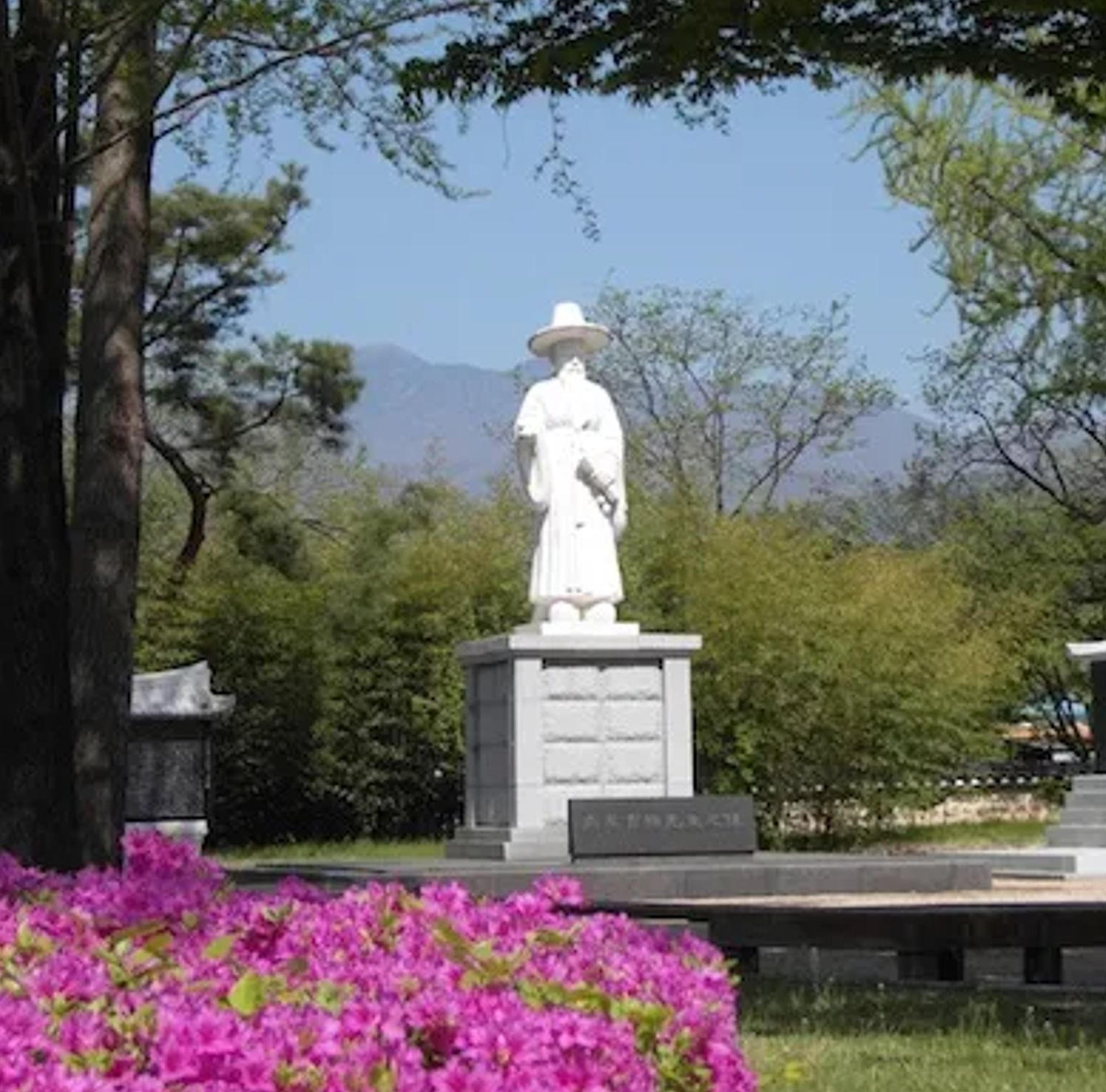 Statue of Nammyeong Jo Shik amid azaleas at Sancheonjae
