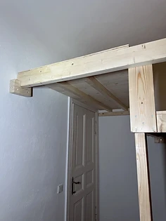 Auskragung der Hochebene über dem Türbereich, an der Wand verankert
