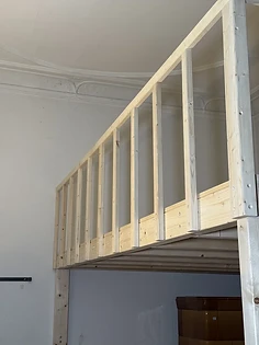 Geländer der Liegeebene vor Altbau-Stuckdecke, Detailaufnahme